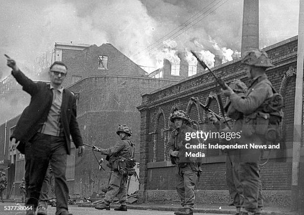 As buildings burn, British Army troops patrol the streets after being deployed to end the Battle of the Bogside, Derry, Northern Ireland, August 15,...