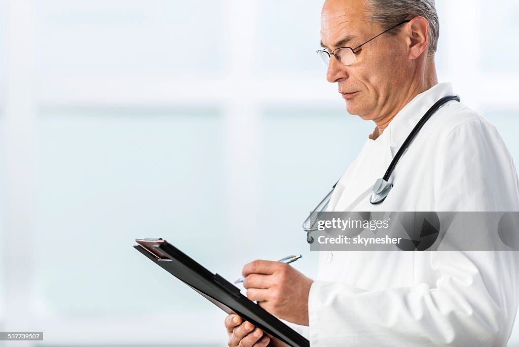 Doctor writing a medical chart.