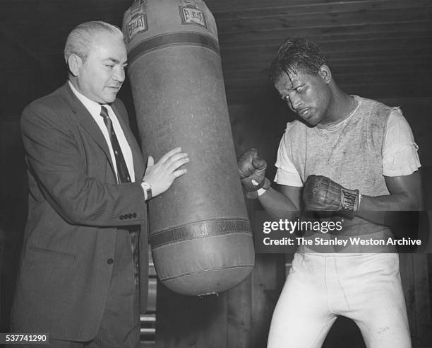 Sugar Ray Robinson goes to work on the bag in preperation for his May 1st bout with Middleweight Gene Fullmer for the title as former lightweight...