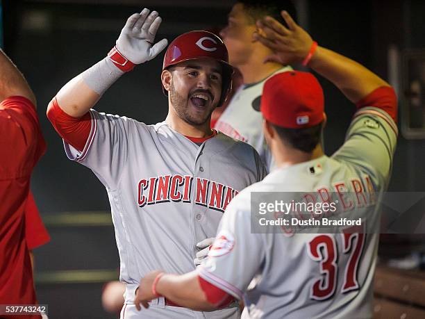 Eugenio Suarez of the Cincinnati Reds celebrates after hitting a solo home run for his second of the game against the Colorado Rockies in the sixth...