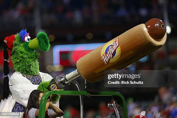 The Phillie Phanatic dressed in Greek ethnic clothing fires hot dogs into the stands during a game between the Milwaukee Brewers and the Philadelphia...