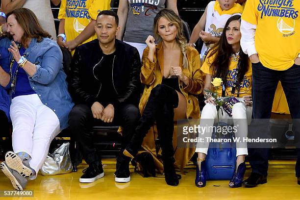 Singer John Legend with wife/model Chrissy Teigen sit courtside in Game 1 of the 2016 NBA Finals at ORACLE Arena on June 2, 2016 in Oakland,...