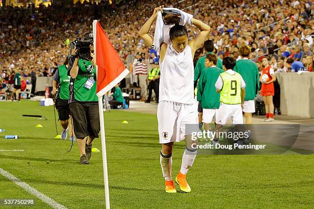 Yuki Ogimi of Japan leaves the pitch after receiving her second yellow card of the game for fouling Julie Johnston of United States of America and is...