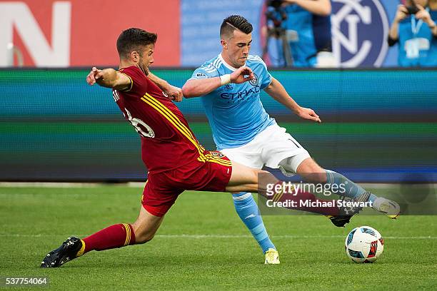 Midfielder Jack Harrison of New York City FC and defender Chris Wingert of Real Salt Lake vie for the ball during the match at Yankee Stadium on June...