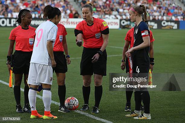 Referee Margaret Domka tosses the coin with team captains Yuki Ogimi of Japan and Becky Sauerbrunn of United States of America prior to their...