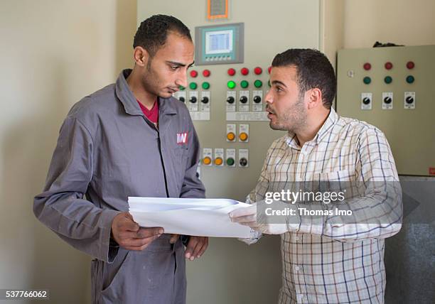 Amman, Jordan Two employees of a decentralized sewage treatment plant in the Public Security Directorate consult with each other in front of a...