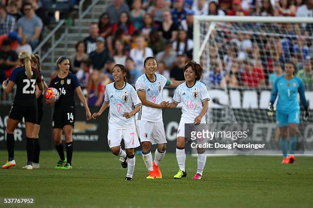Yuki Ogimi of Japan celebrates her goal against Hope Solo of United States of America with Mana Iwabuchi of Japan as Morgan Brian and Allie Long of...