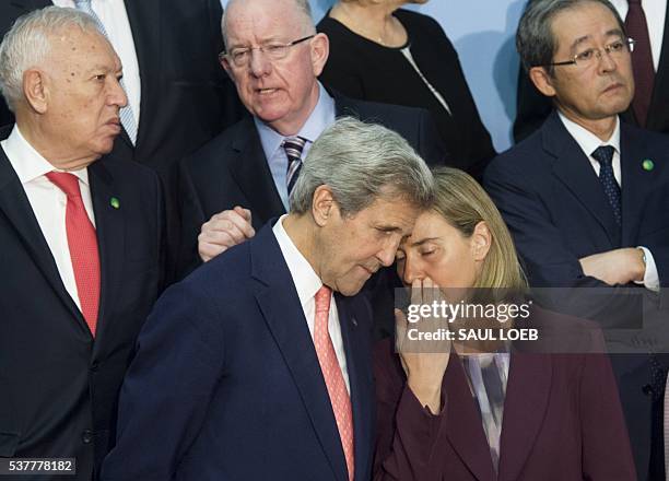 Secretary of State John Kerry speaks with European Union High Representative for Foreign Affairs Federica Mogherini as they arrive for a family photo...