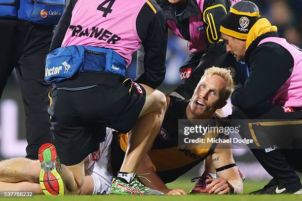 Steven Morris of the Tigers reacts after he suffers a leg injury in a contest with Robin Nahas of the Kangaroos during the round 11 AFL match between...