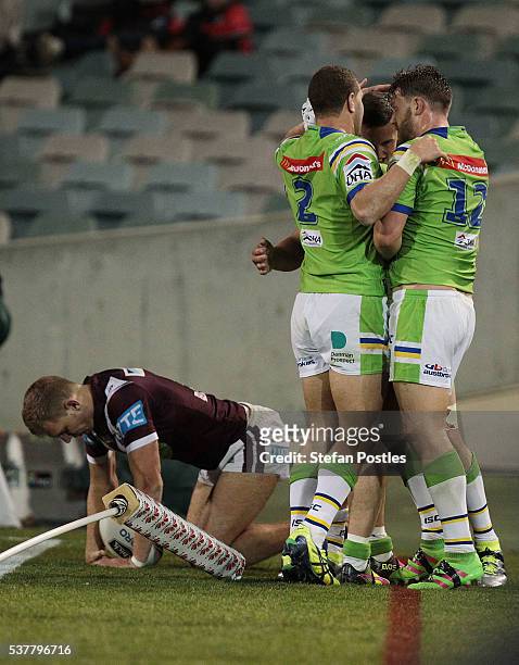 Raiders players congratulate Jack Wighton after he stopped Tom Trbojevic of the Sea Eagles from scoring a try during the round 13 NRL match between...