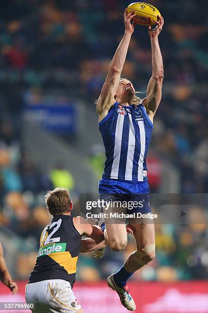 Ben Brown of the Kangaroos marks the ball David Astbury of the Tigers during the round 11 AFL match between the North Melbourne Kangaroos and the...