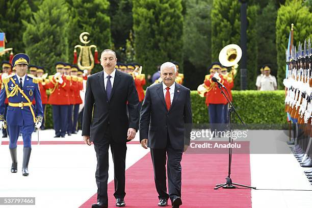 Azerbaijani President Ilham Aliyev and Turkish Prime Minister Binali Yildirim walk past the honor guard during an official welcome ceremony prior to...