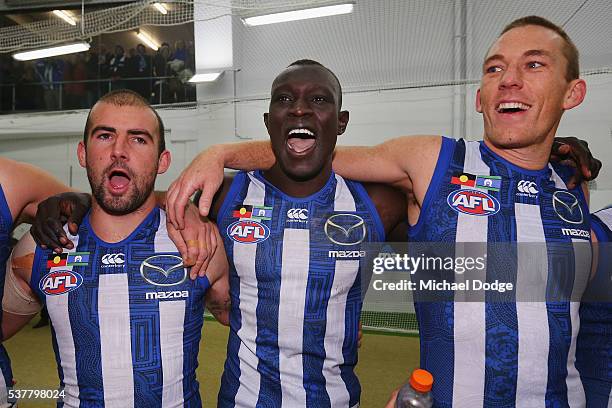 Ben Cunnington Majak Daw and Drew Petrie of the Kangaroos sing the club song after winning during the round 11 AFL match between the North Melbourne...