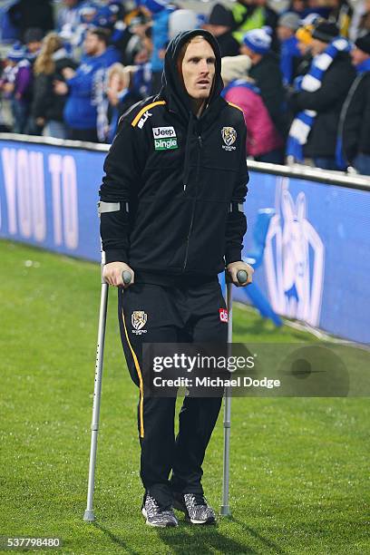 Steven Morris of the Tigers hobbles off on crutchers after defeat during the round 11 AFL match between the North Melbourne Kangaroos and the...