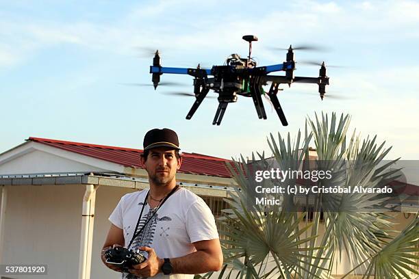 young businessman operates unmanned aerial vehicle (uav). - octocóptero fotografías e imágenes de stock