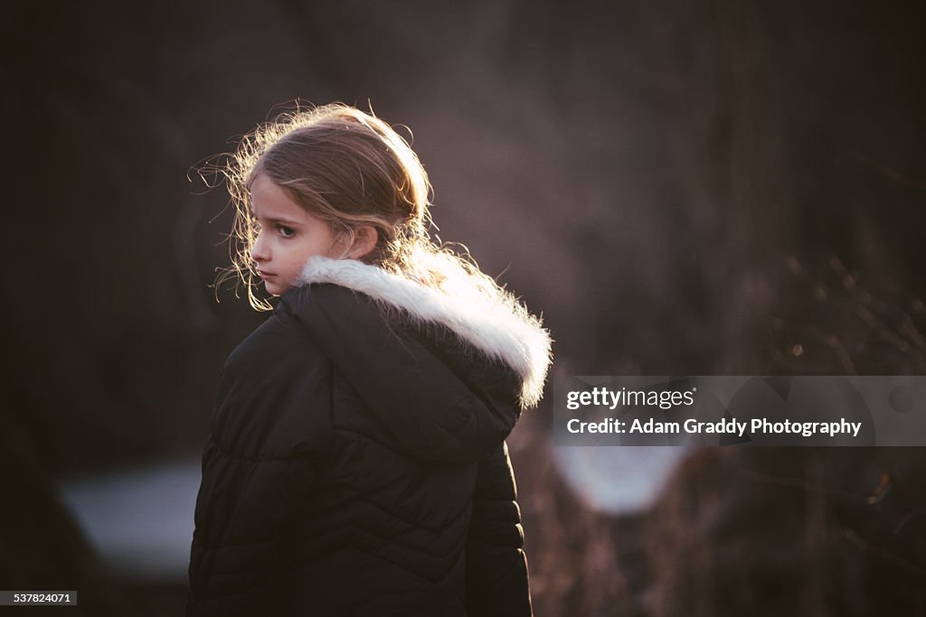 Child playing outside and looking over shoulder