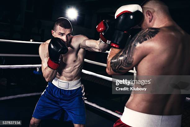 two boxers fighting in a boxing ring - boxing young men stock pictures, royalty-free photos & images