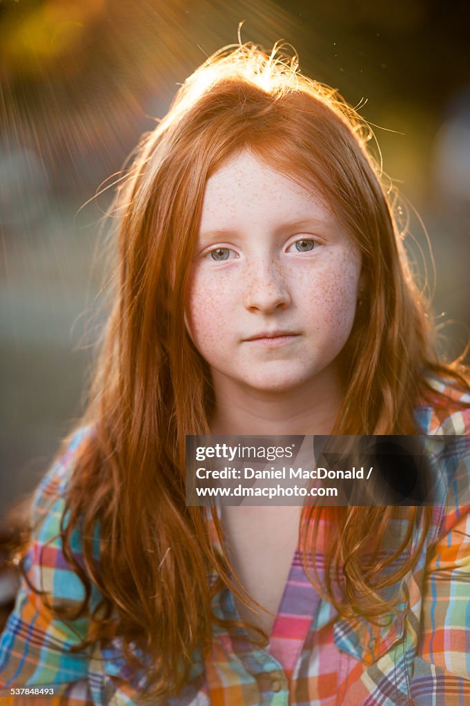 Young redheaded girl in plaid shirt in autumn