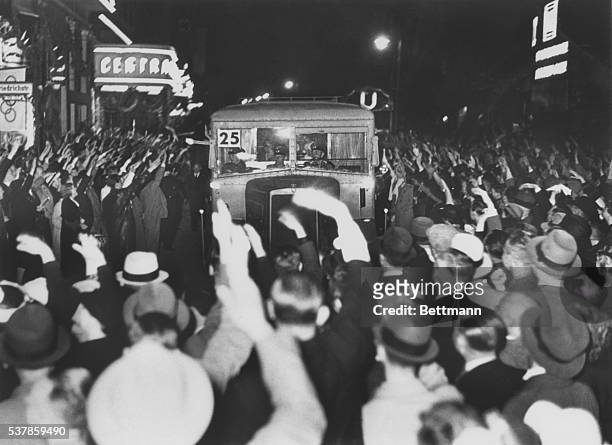 Bus loaded with French athletes who compete in the Olympic games, are given the Nazi salute and greeted with cheer on the arrival in Berlin recently.