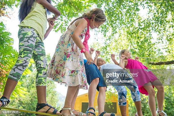 having fun outdoors - slacklining stock pictures, royalty-free photos & images