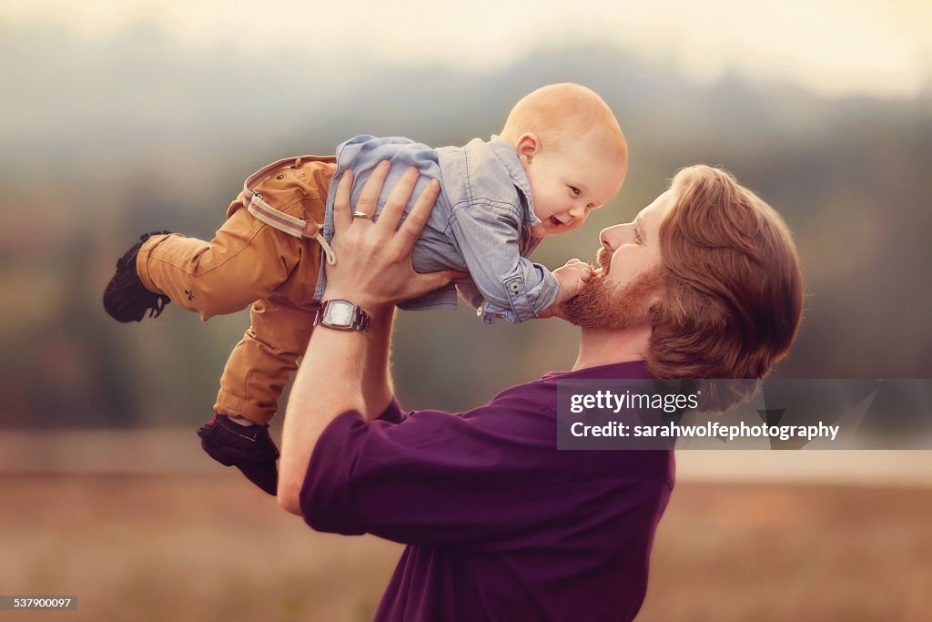 Happy baby being lifted into air by dad