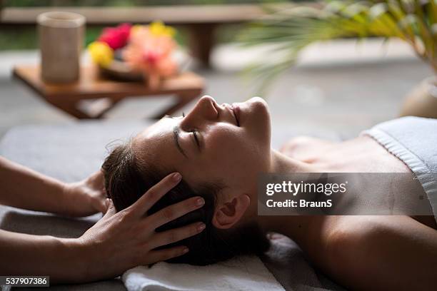 rilassata donna che si diverte in un massaggio alla testa alla spa. - head massage foto e immagini stock