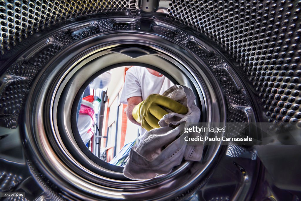 Man loading his washing machine: seens from inside