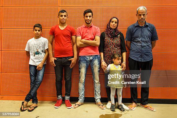 Kudhair Samandari, his wife Entida and their children, migrants from Babylon in Iraqe, pose for a group photo in the gymnasium where they live that...