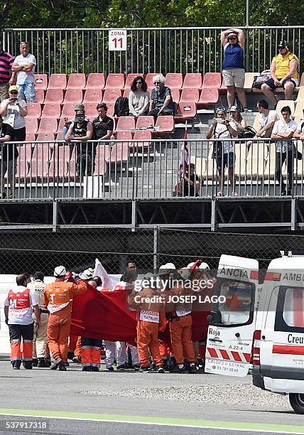 Team Moto2 Spanish rider Luis Salom is evacuated by medical personnel after resulting injured in an accident at the Catalunya racetrack in Montmelo,...