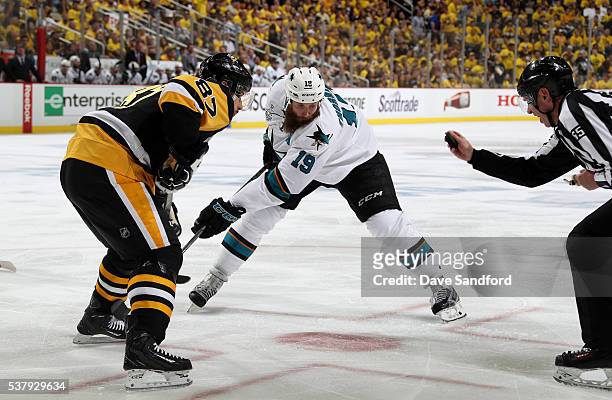 Linesman Pierre Racicot sets up to drop the puck for the face-off between Joe Thornton of the San Jose Sharks and Sidney Crosby of the Pittsburgh...