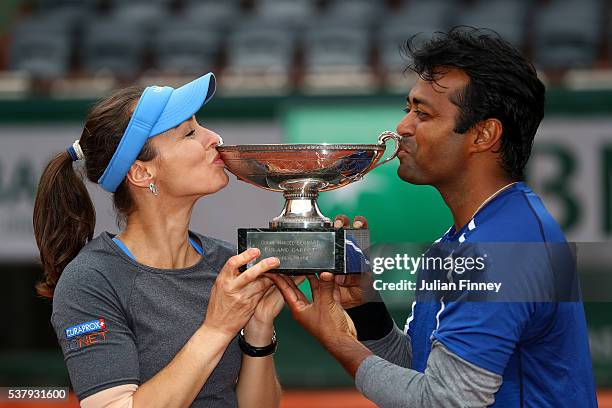 Martina Hingis of Switzerland and Leander Paes of India kiss the trophy following victory during the Mixed Doubles final match against Sania Mirza of...