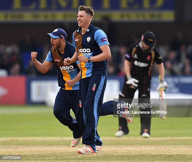Matt Critchley of Derbyshire Falcons is congratulated by Alex Hughes on taking the wicket of Ben Raine of Leicestershire Foxes during the NatWest T20...