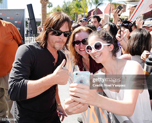 Norman Reedus takes a selfie with a fan at "Extra" at Universal Studios Hollywood on June 3, 2016 in Universal City, California.