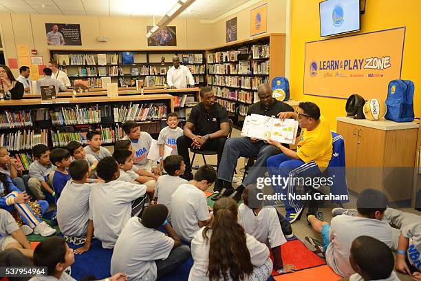 Harrison Barnes of the Golden State Warriors and former player Adonal Foyle reads a book with the children at the 2016 NBA Finals Cares Legacy...