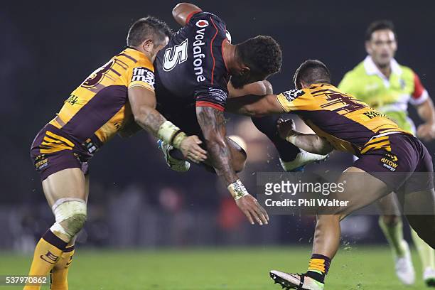 Manu Vatuvei of the Warriors is tackled by Corey Parker and Kodi Nikorima of the Broncos during the round 13 NRL match between the New Zealand...