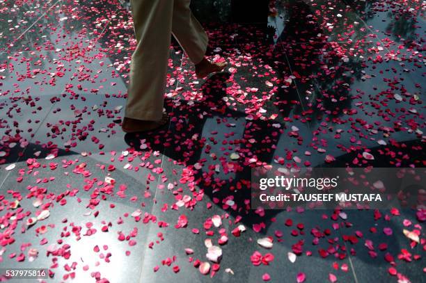 An Indian Border Security Force soldier walks over rose petals at a memorial for those killed in conflict following a wreath-laying ceremony for...