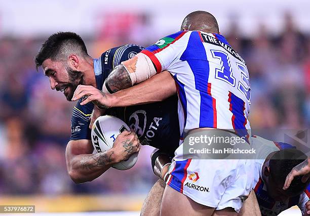 James Tamou of the Cowboys is tackled by Jeremy Smith of the Knights during the round 13 NRL match between the North Queensland Cowboys and the...