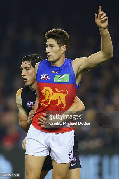 Jacob Weitering of the Blues clings onto Jonathan Freeman of the Lions who calls for the ball during the round 11 AFL match between the Carlton Blues...