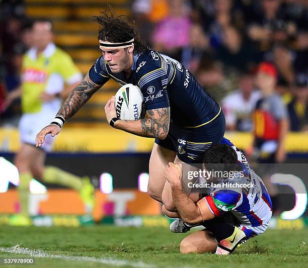 Ethan Lowe of the Cowboys is tackled by Jack Cogger of the Knights during the round 13 NRL match between the North Queensland Cowboys and the...