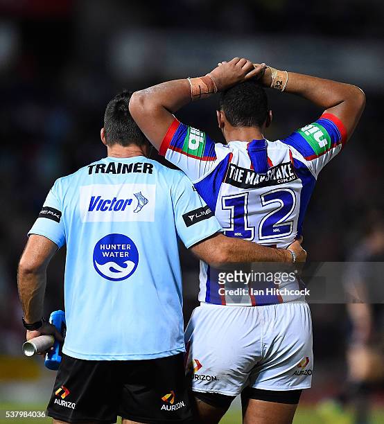 Pauli Pauli of the Knights is embracd by Knights trainer Craig Smith during the round 13 NRL match between the North Queensland Cowboys and the...