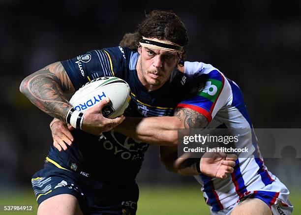 Ethan Lowe of the Cowboys is tackled by Tyler Randell of the Knights during the round 13 NRL match between the North Queensland Cowboys and the...