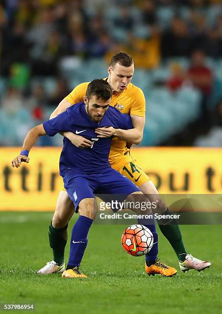 Ioannis Giaaniotas of Greece is tackled by Brad Smith of the Socceroos during the international friendly match between the Australian Socceroos and...
