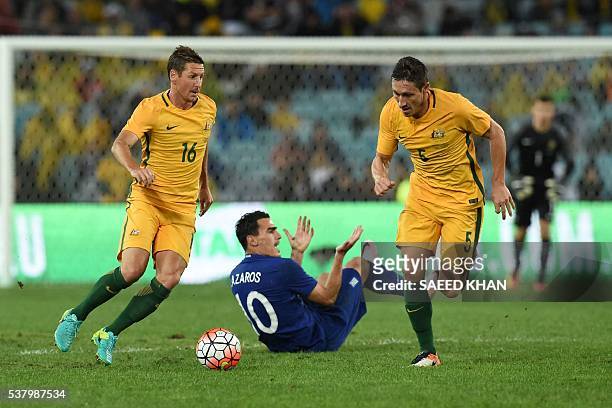 Australia's Nathan Burns and Mark Milligan control the ball as Greece's Lazaros Christodoulopoulos reacts during their international friendly...
