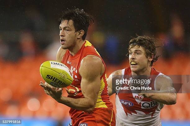 Jesse Lonergan of the Suns handballs during the round 11 AFL match between the Gold Coast Suns and the Sydney Swans at Metricon Stadium on June 4,...