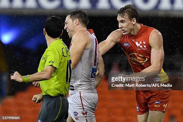 Tom Lynch of the Suns punches Jeremy Laidler of the Swans during the round 11 AFL match between the Gold Coast Suns and the Sydney Swans at Metricon...