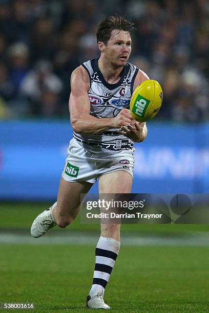 Patrick Dangerfield of the Cats handballs during the round 11 AFL match between the Geelong Cats and the Greater Western Sydney Giants at Simonds...