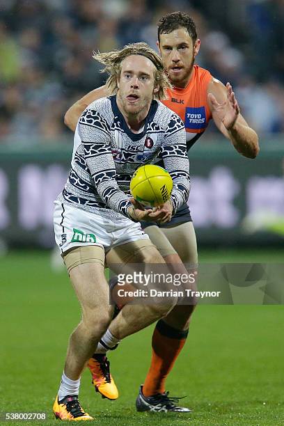 Cameron Guthrie of the Cats handballs during the round 11 AFL match between the Geelong Cats and the Greater Western Sydney Giants at Simonds Stadium...