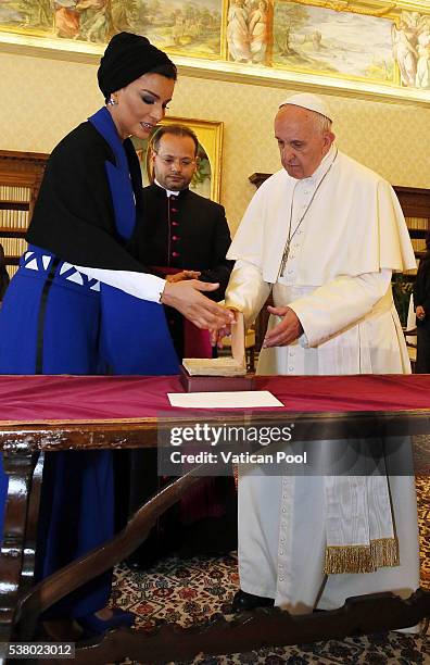 Pope Francis exchanges gifts with Sheikha Mozah bint Nasser Al Missned at his private library in the Apostolic Palace on June 4, 2016 in Vatican...