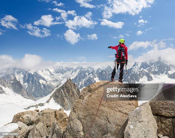 mountaineer on top of the mountain pointing towards the alps - chamonix stock pictures, royalty-free photos & images