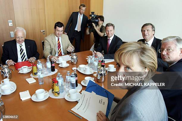 Angela Merkel , head of the Christian Democratic Union party and candidate for Chancellor of the conservative opposition union, sits on a table with...